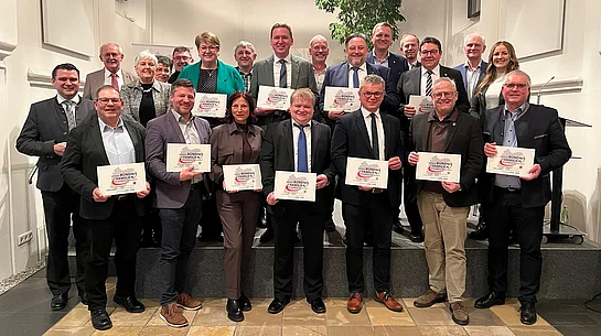 Das Foto zeigt die feierliche Auszeichnung der Stadt Teublitz mit dem Silber-Siegel als familienfreundliche Kommune, bei der Vertreterinnen und Vertreter der teilnehmenden Kommunen gemeinsam die Urkunden präsentieren.
