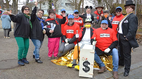 Das Foto zeigt eine bunt kostümierte Faschingsgruppe, die beim Rathaussturm ausgelassen posiert und mit Requisiten sowie symbolischen Accessoires die närrische Machtübernahme darstellt.