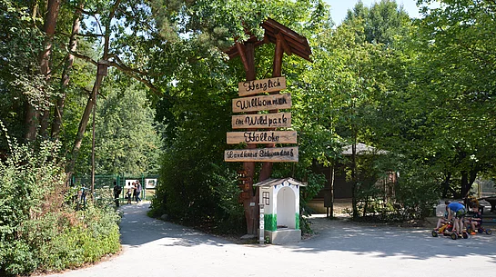 Ein aus alten Bäumen und aus Holz errichtete Willkommensschild begrüßt die Besucher des Wild- und Freizeitparks Höllohe.