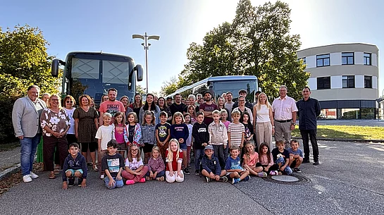 Gruppenfoto der künftigen Schulkinder mit Eltern und Begleitpersonen bei der Schnupperfahrt in Teublitz. Die Kinder stehen und sitzen im Vordergrund, dahinter sind zwei Busse zu sehen.